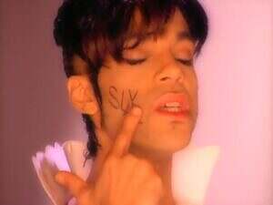Prince, eyes closed with SLAVE on his cheek