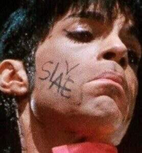Prince performing with "SLAVE" on his face in 1995